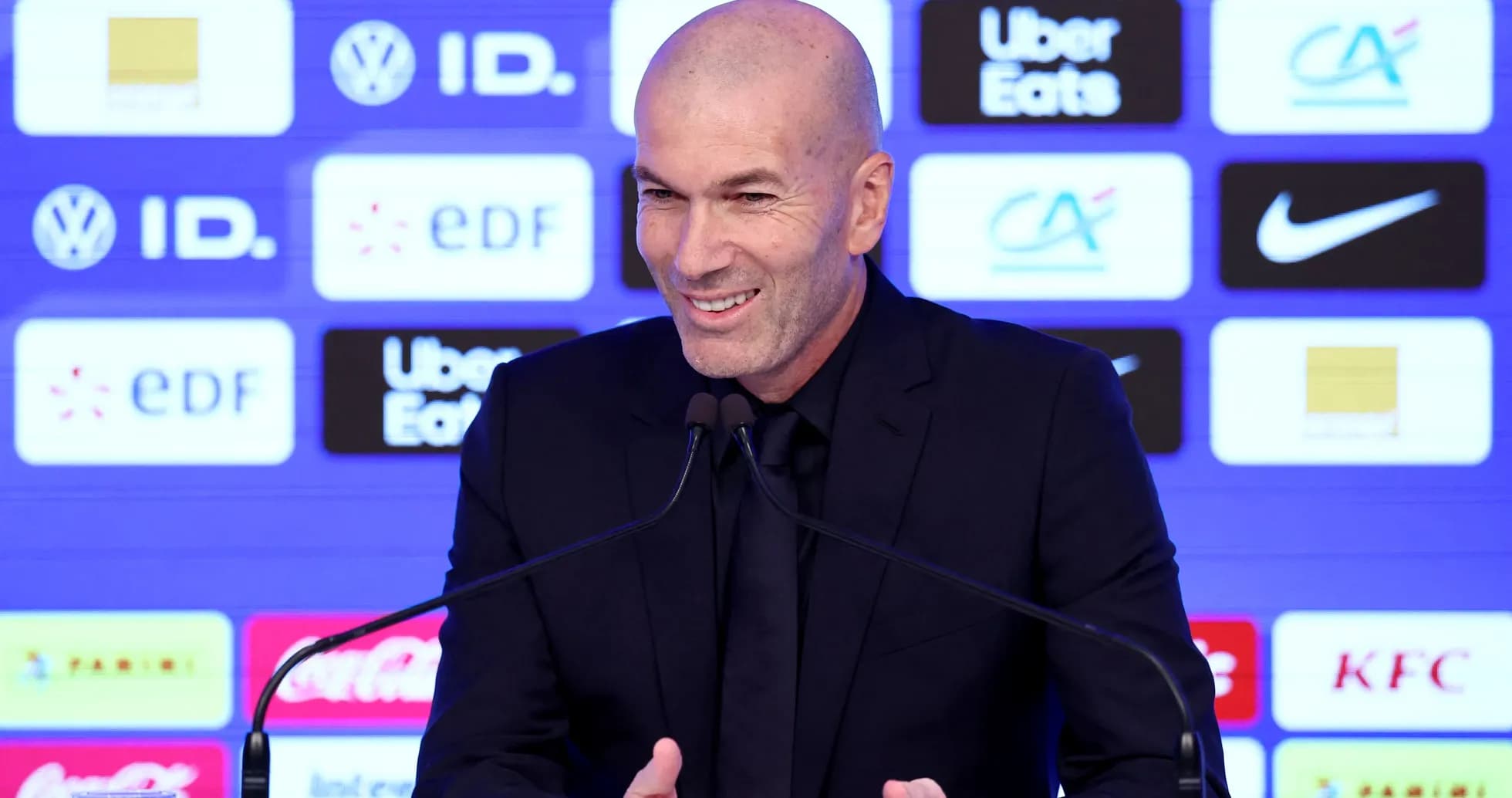 Manager speaking at press conference with sponsor logos