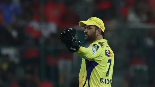 Cricketer wearing yellow jersey gesturing on field