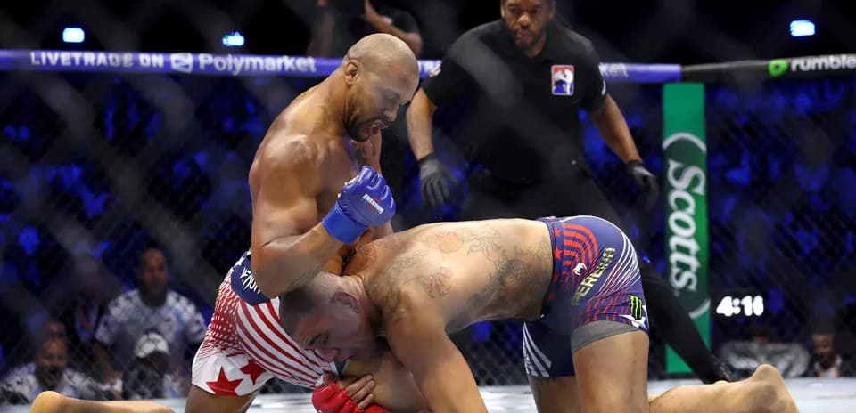 Fighter delivering punches to opponent on mat