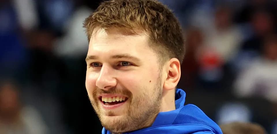 Player smiling in blue warm-up jacket on court