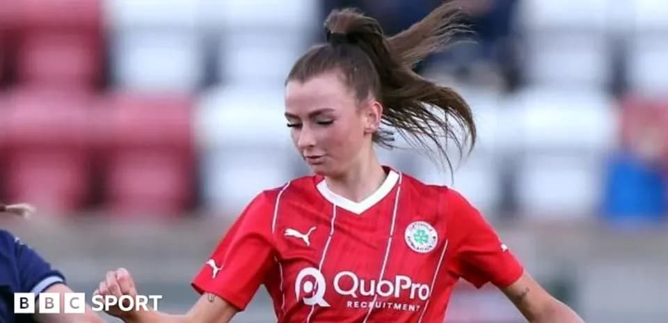 Player in red kit dribbling the ball during match