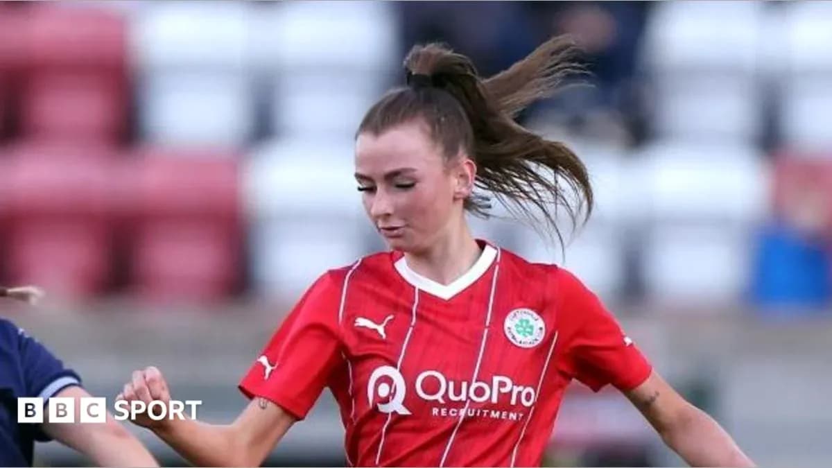Player in red kit dribbling the ball during match