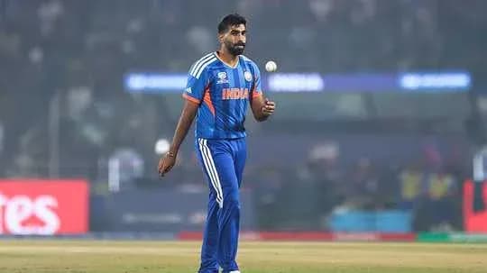 Cricketer walking on field holding a ball