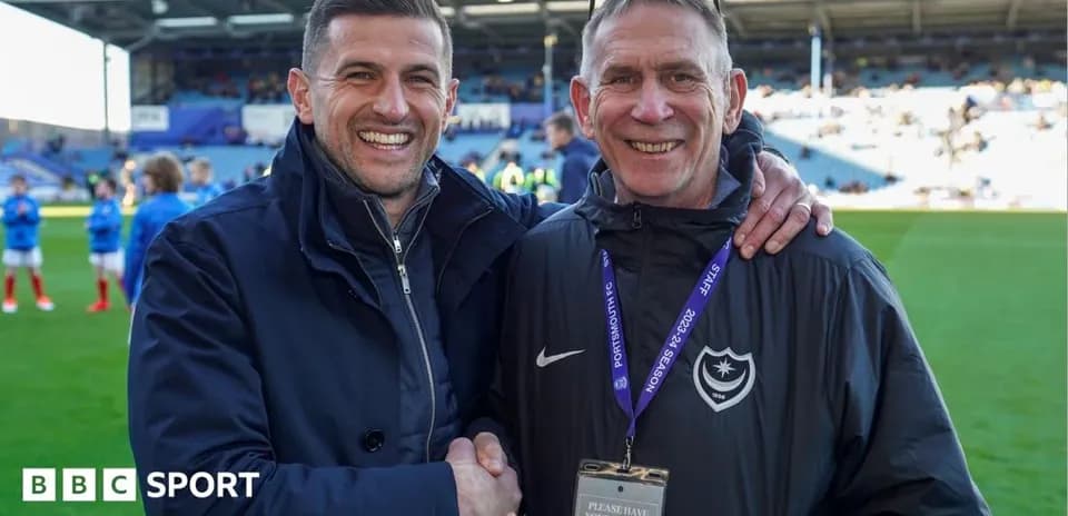 Two men shaking hands on football pitch