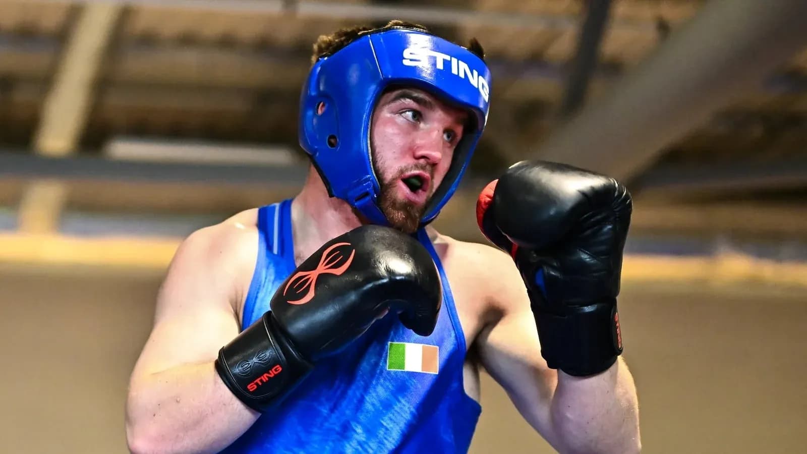 Boxer in blue gear practicing punches during training