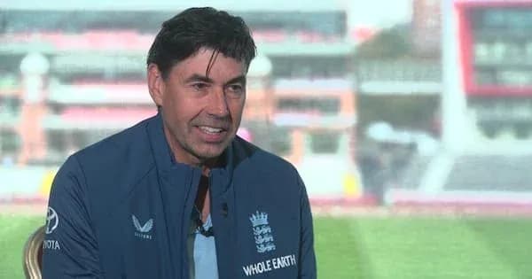 Man in England cricket jacket speaking at event