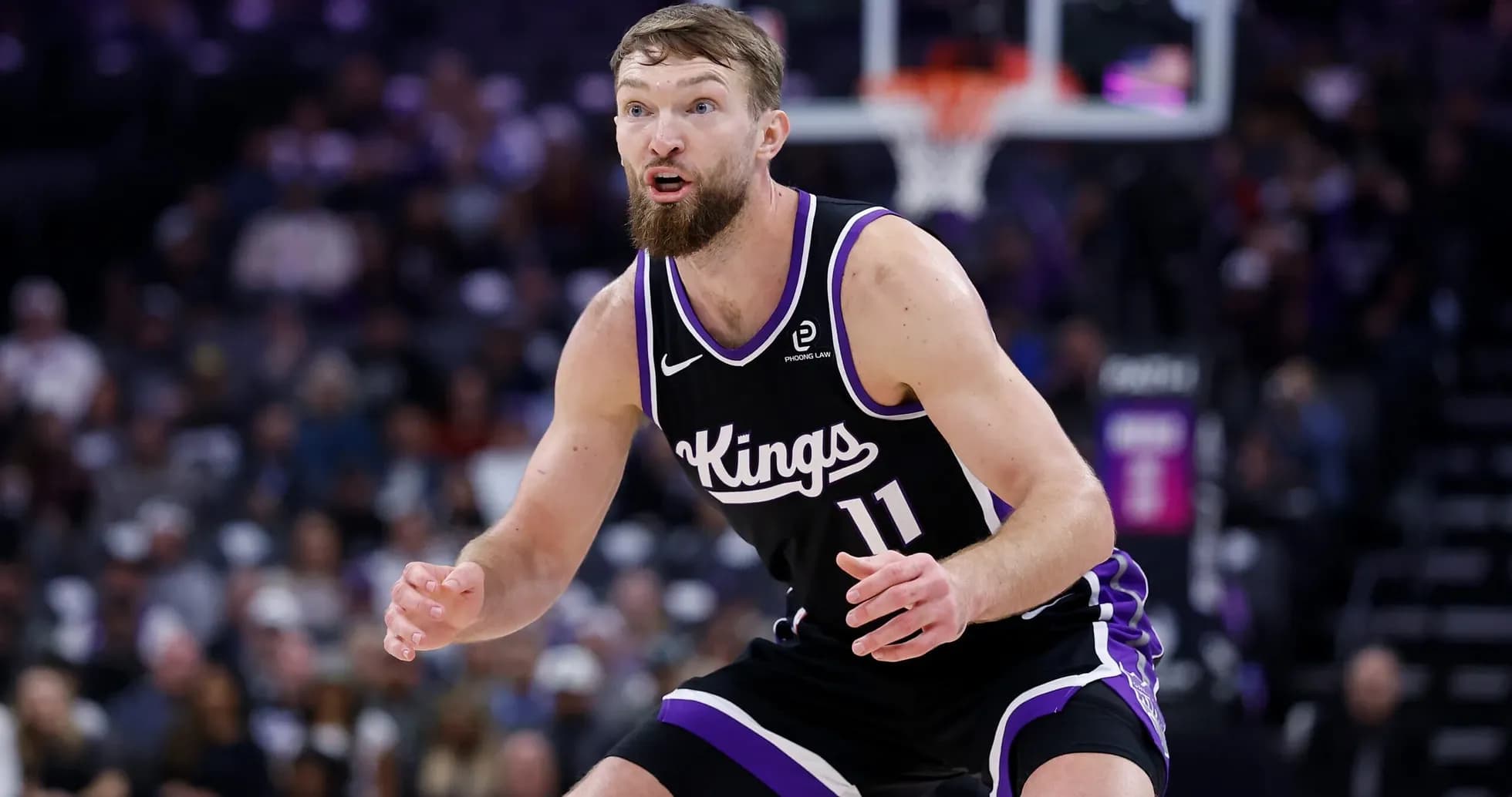 Player in black Kings uniform defending on court
