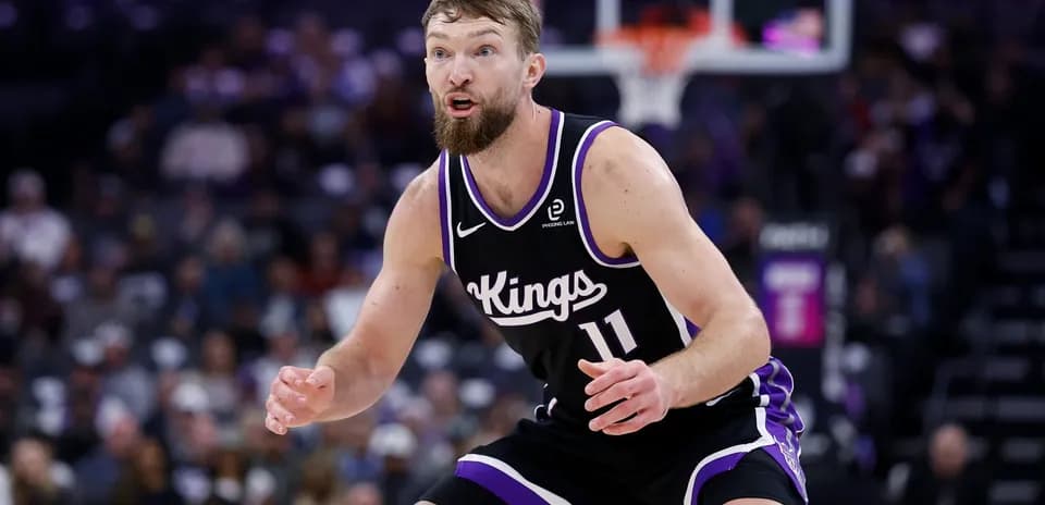 Player in black Kings uniform defending on court