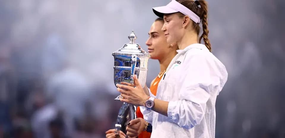 Two tennis players holding trophies after a match