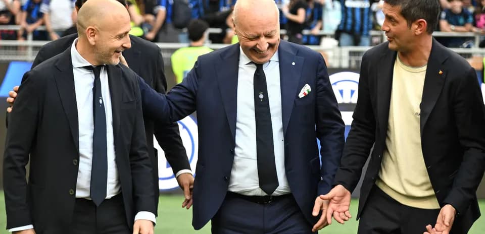 Three coaches interacting on the pitch before a match