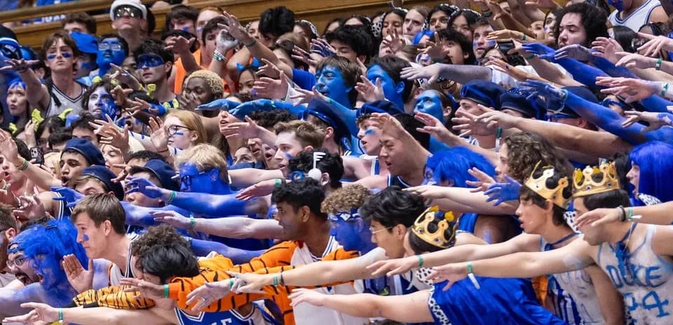 Duke University fans in blue cheering at a game