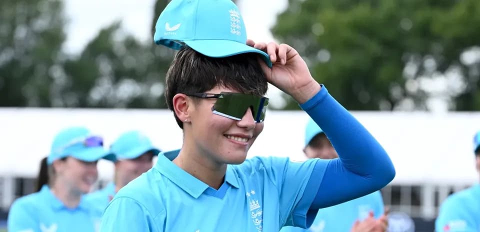 Cricketer adjusting cap during team celebration