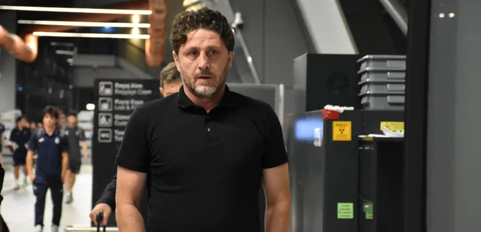 Coach walking through airport terminal with team members