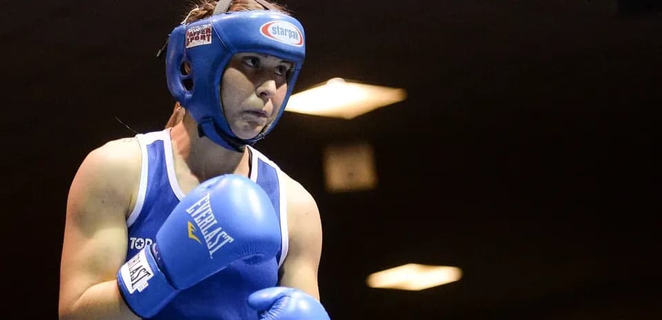 Female boxer in blue gear preparing to fight