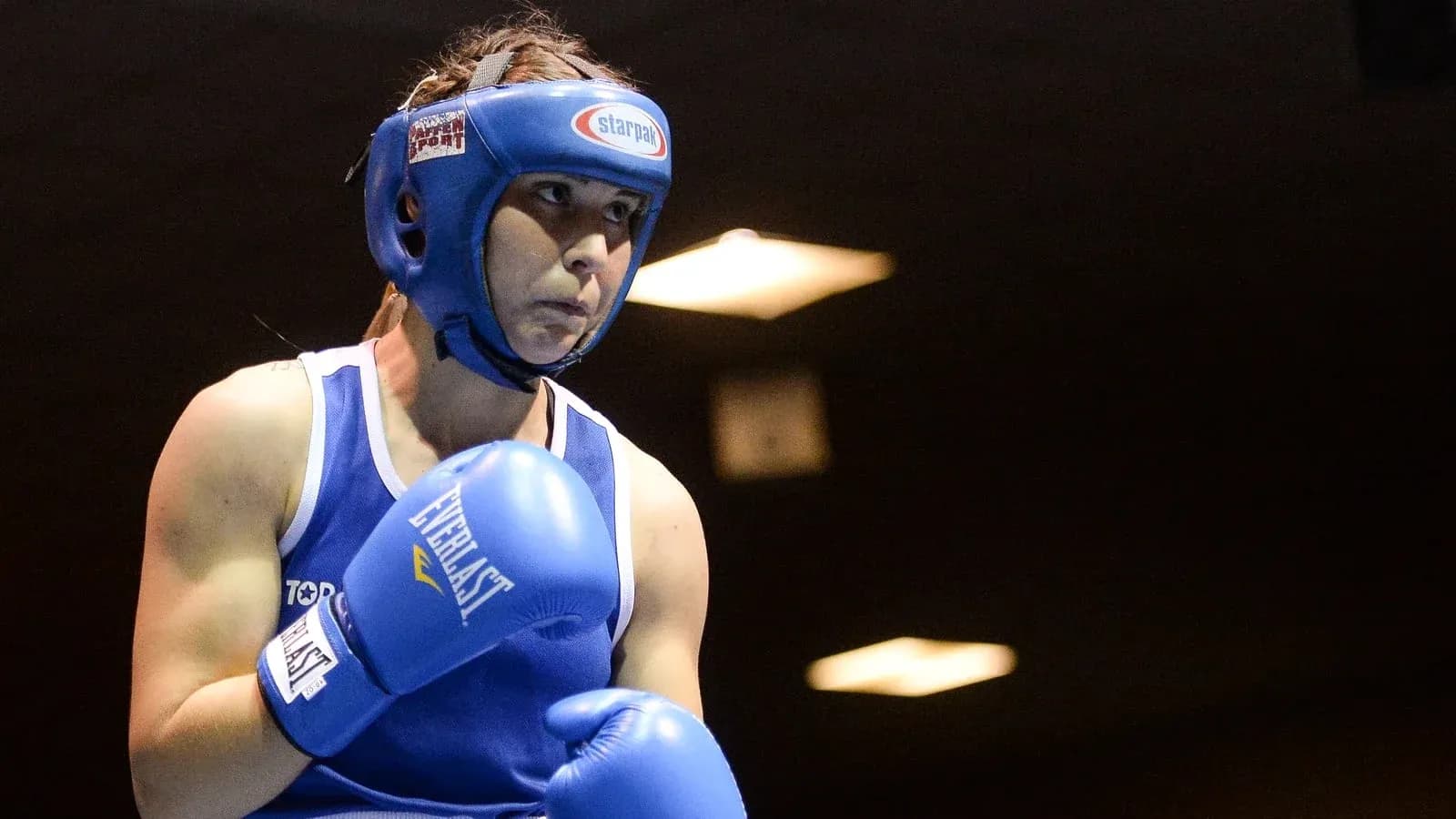 Female boxer in blue gear preparing to fight