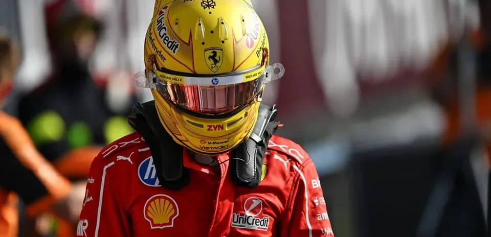 Driver in Ferrari suit and helmet at pit lane