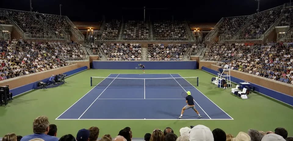 Players competing in a night tennis match