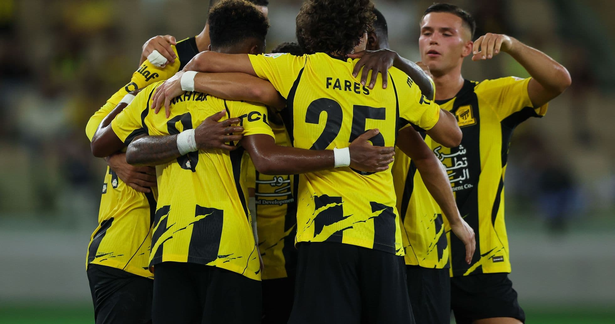 Players celebrating a goal in yellow uniforms
