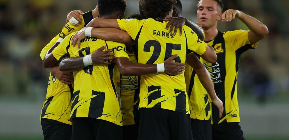 Players celebrating a goal in yellow uniforms