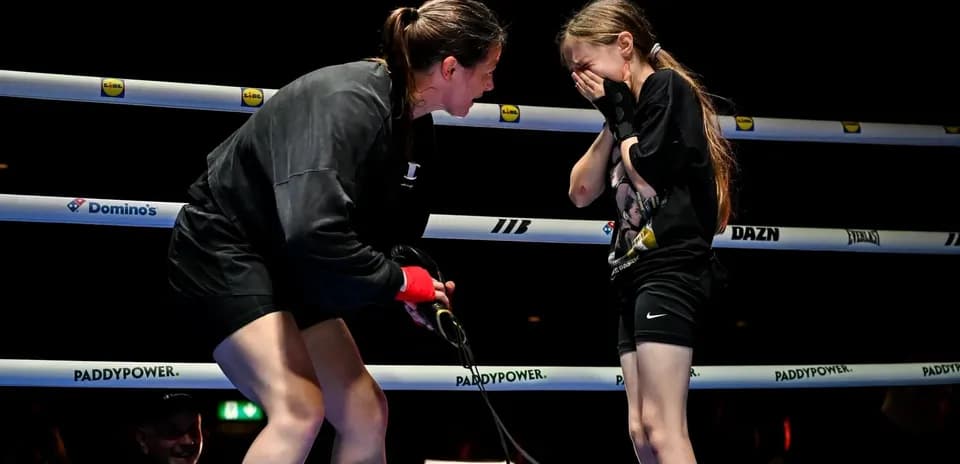Boxer comforting young girl in the ring