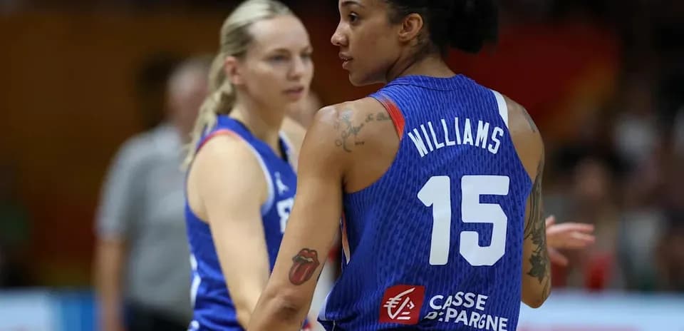 Two basketball players in blue jerseys on court