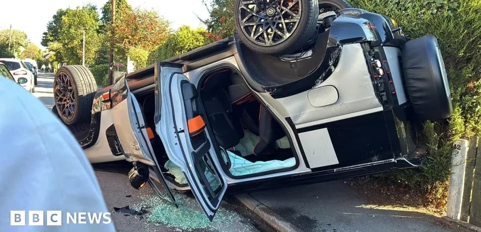 Upside-down car on side of road with debris