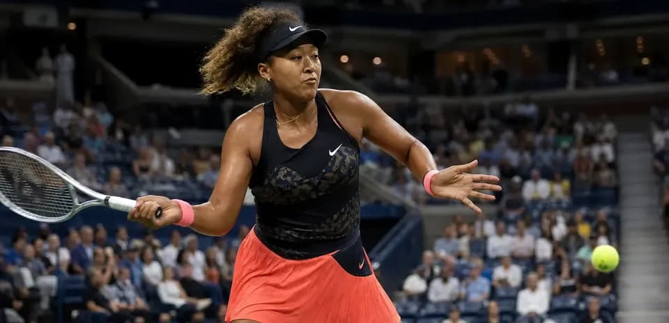 Naomi Osaka preparing to hit a tennis ball