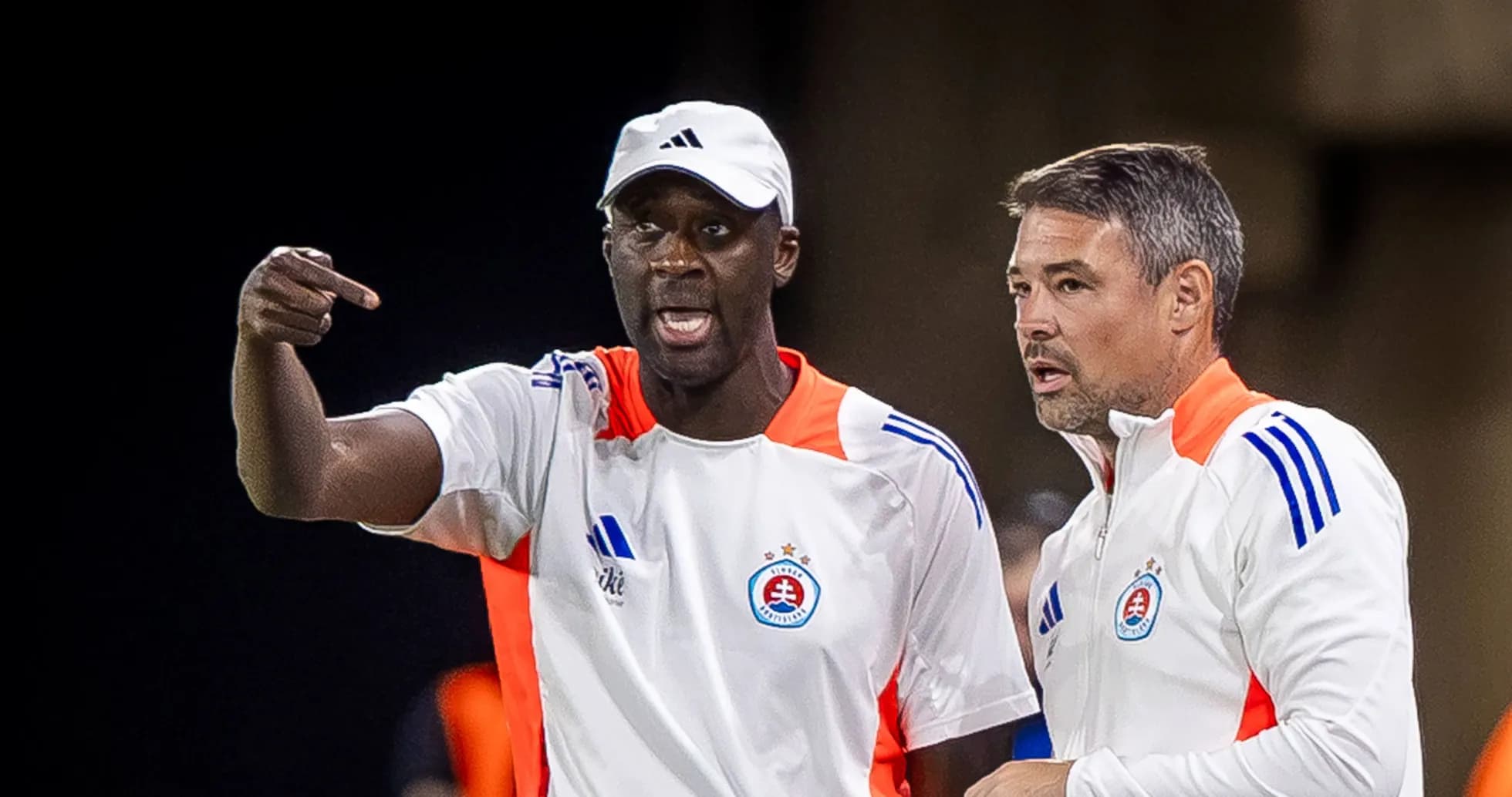 Two coaches discussing strategies during match
