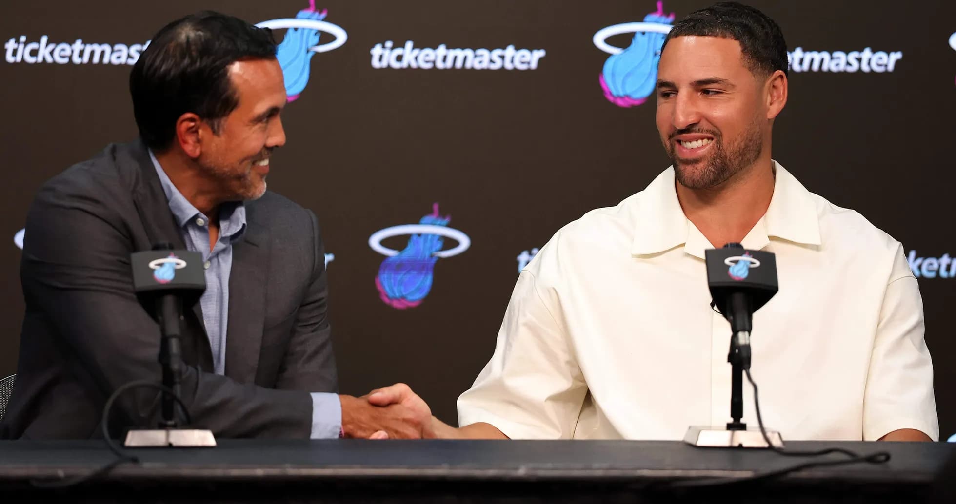 Coach and player shaking hands at press conference