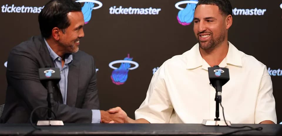 Coach and player shaking hands at press conference