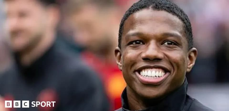 Smiling player in black jacket during warm-up