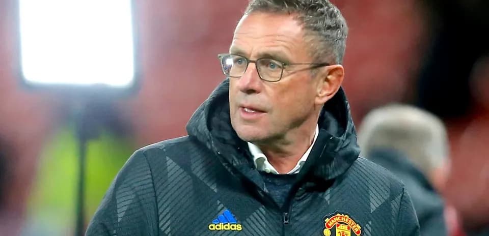 Coach wearing Manchester United jacket on the sidelines