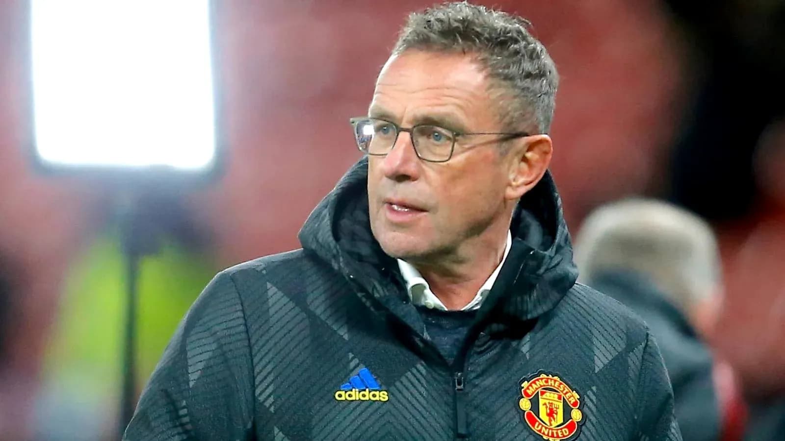 Coach wearing Manchester United jacket on the sidelines