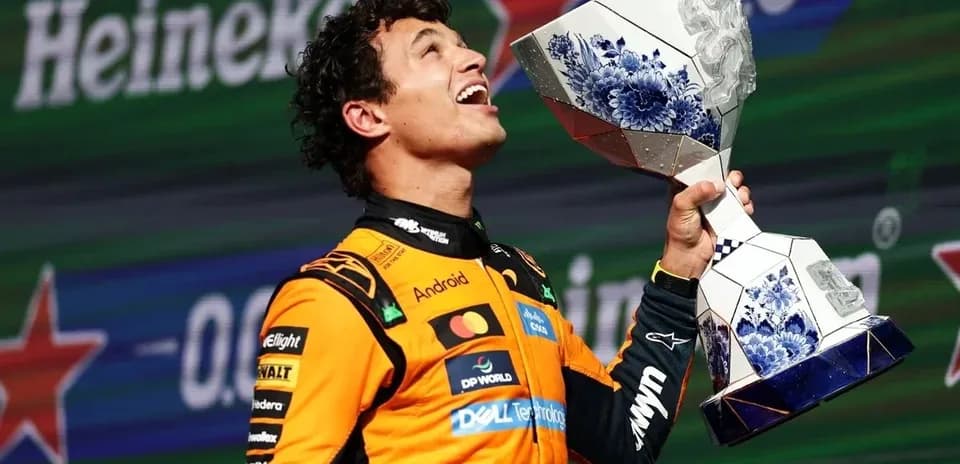 Driver celebrating with trophy on podium