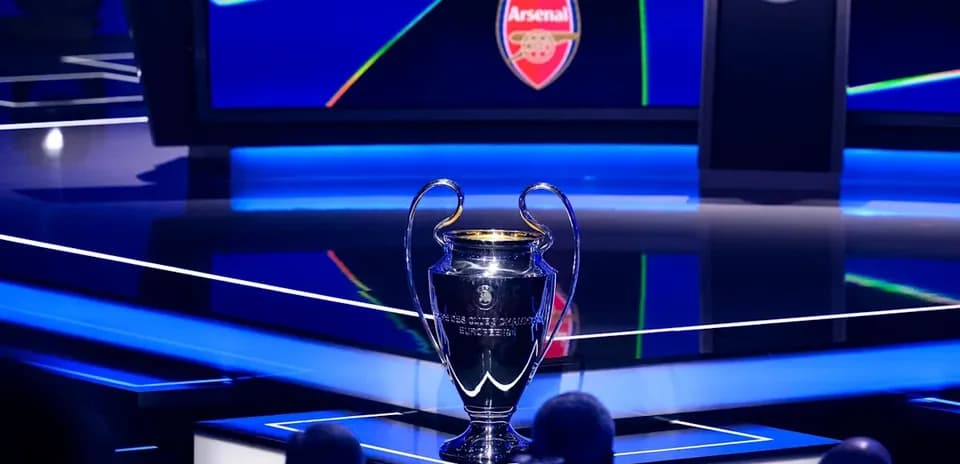 Champions League trophy with Arsenal logo in background