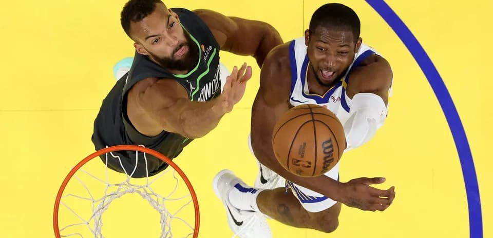 Player shooting the basketball while being defended