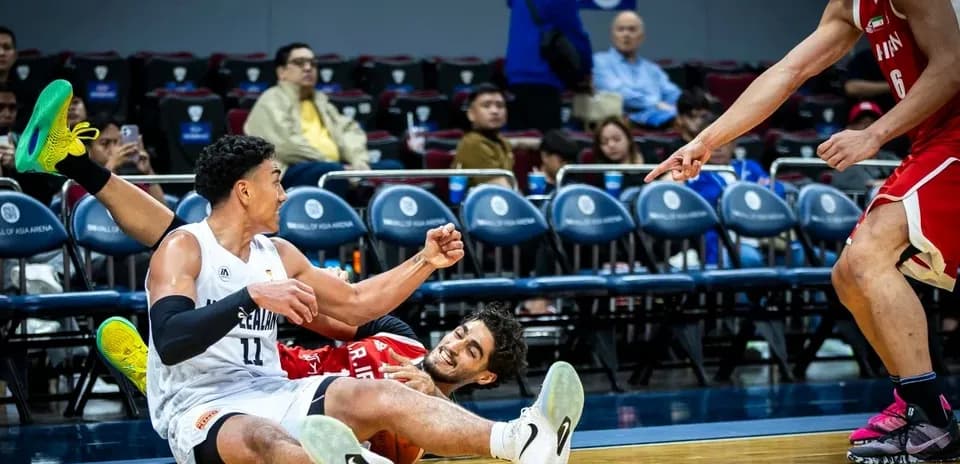Two players on the floor during a basketball game