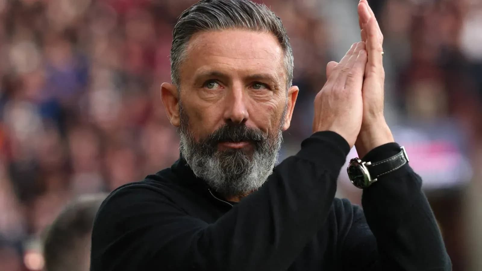 Coach applauding fans during a match