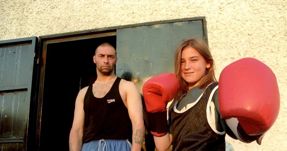 Girl in boxing gloves with trainer standing outside