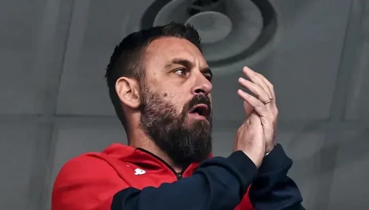 Man in red jacket clapping in stadium