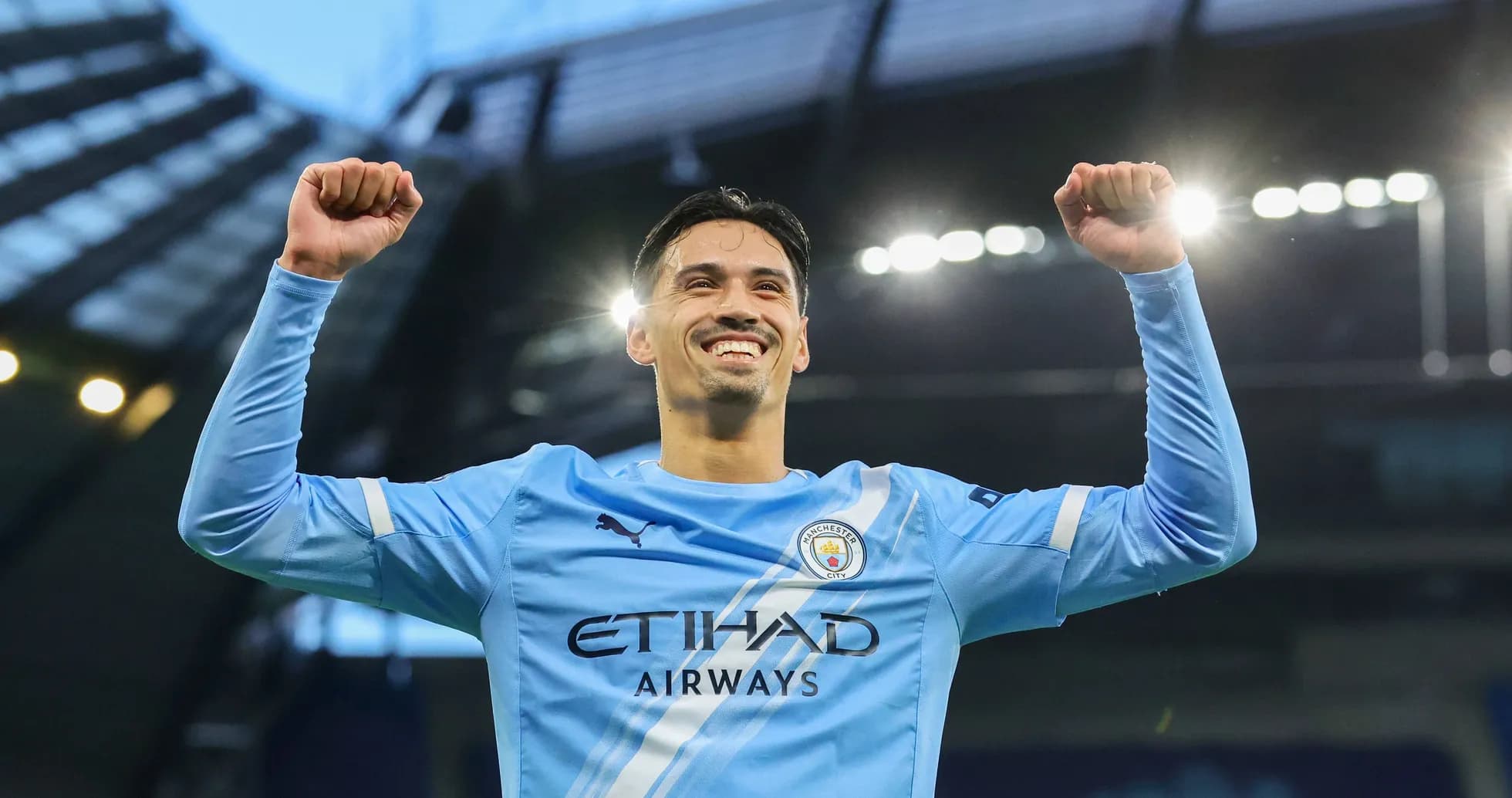 Player celebrating victory with raised arms at stadium