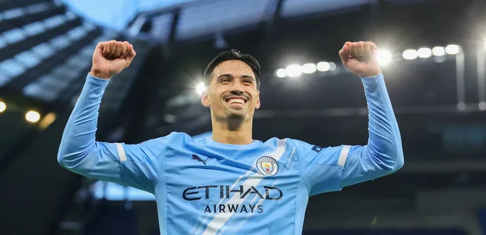 Player celebrating victory with raised arms at stadium