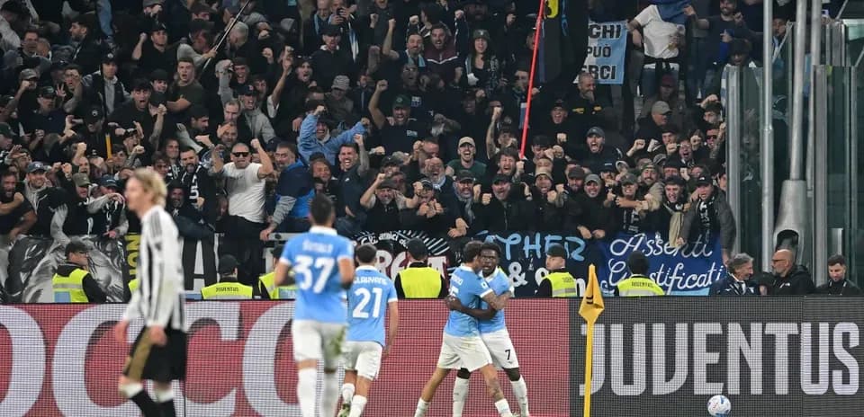 Lazio players celebrating a goal with fans cheering