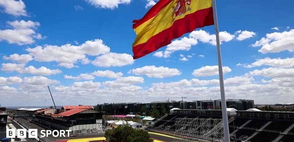Spanish flag flying over racetrack under blue sky