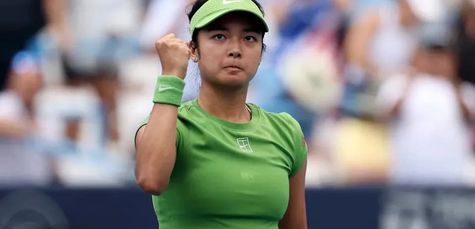 Tennis player celebrating a point in green outfit