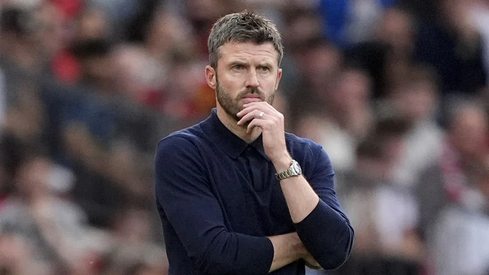 Coach observing the match with a thoughtful expression