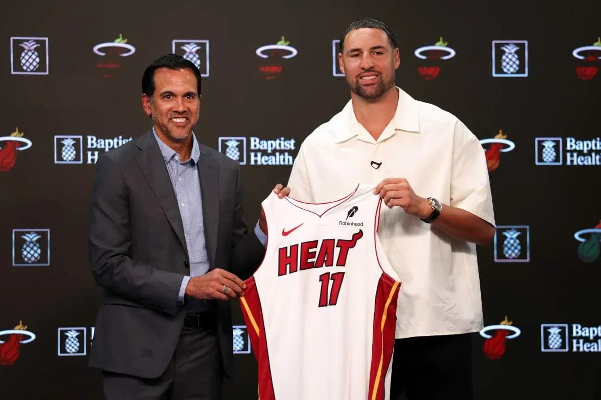 Coach and player holding Miami Heat jersey at event