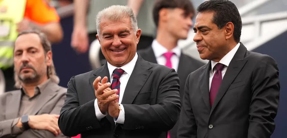 Three men in suits, one clapping, during event