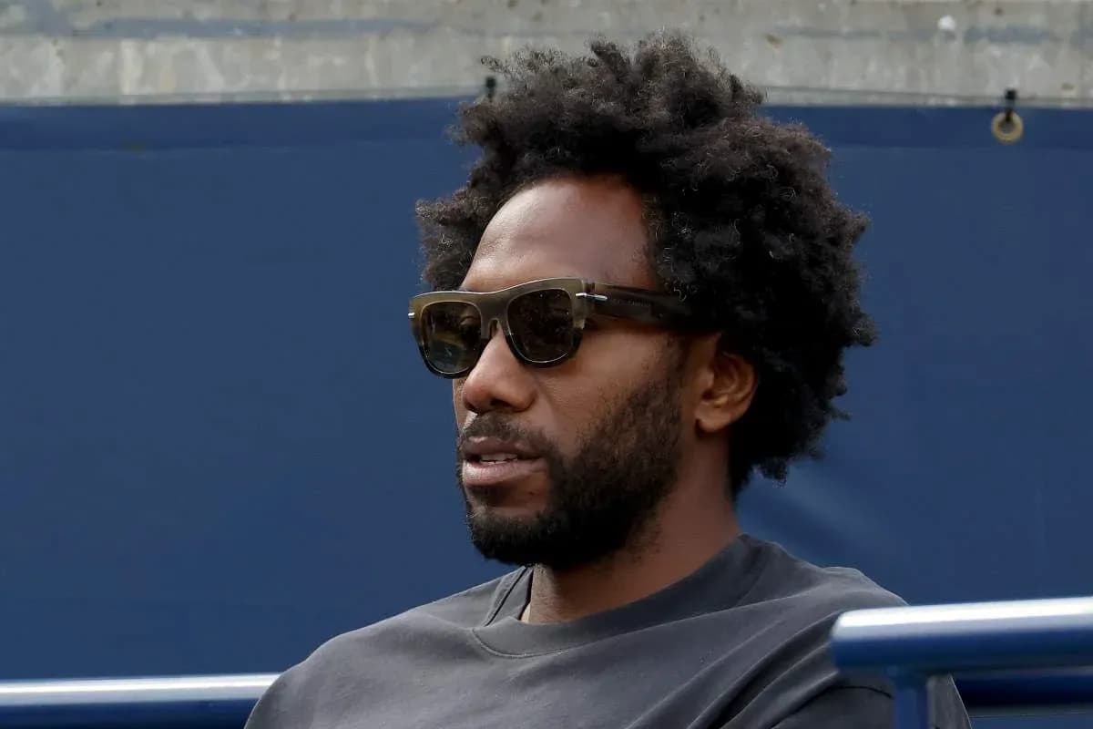 Person wearing sunglasses sitting in a stadium