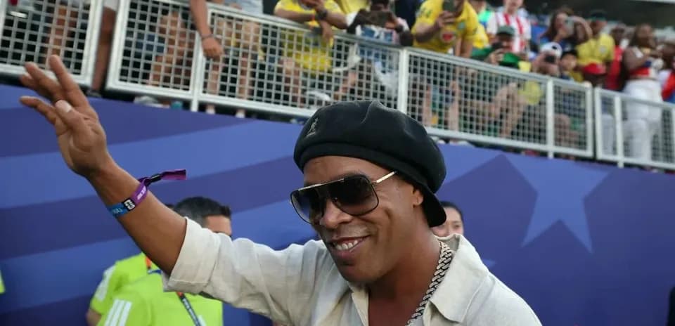 Person waving at fans in stadium stands